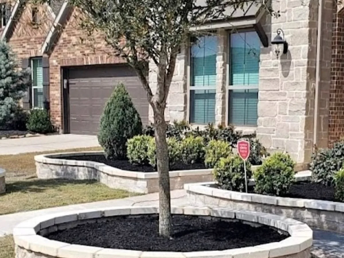 Stone tree ring with mulch in a front yard