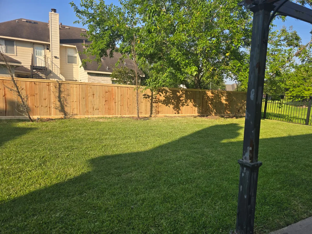 Wood privacy fence framing a lawn with a shed behind it