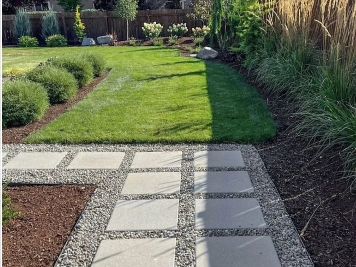 Green lawn with a paver path and planted beds