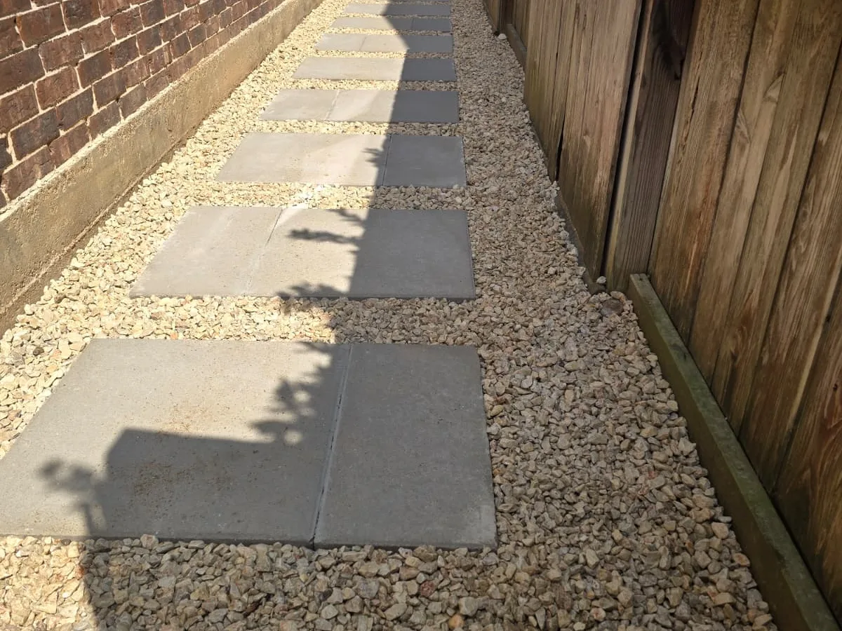 Concrete pads and gravel installed along a side yard
